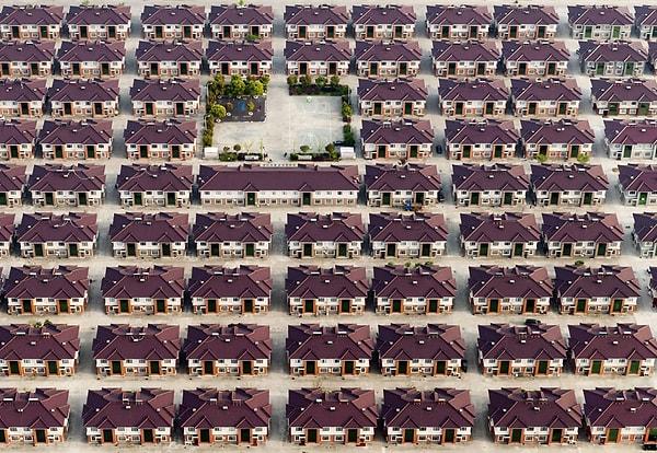 Jiangyin, Çin. Birbirinin kopyası evlerden oluşan sıralar ve ortadaki oyun alanı
