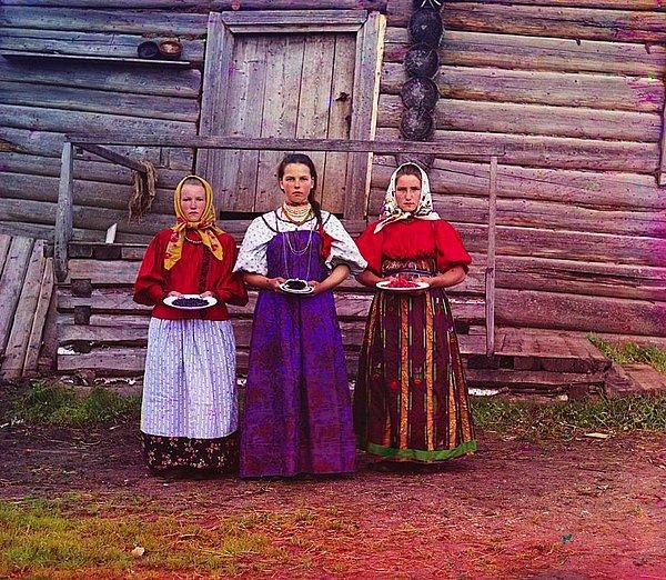22. Kirillov ilçesi yakınlarında üç genç kadın gelen misafirlere meyve ikram ediyorlar.