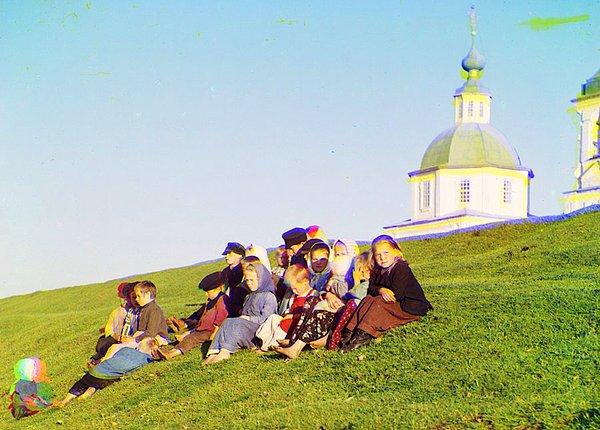 28. Çocuklar Rusya'da Beyaz Göl yakınındaki bir kilisenin önünde oturuyorlar.