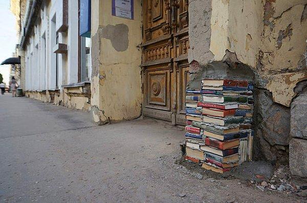 3. Ya da sıvası dökülmüş, tuğlaları kırılmış kütüphane duvarının kitaplarla doldurulduğu,