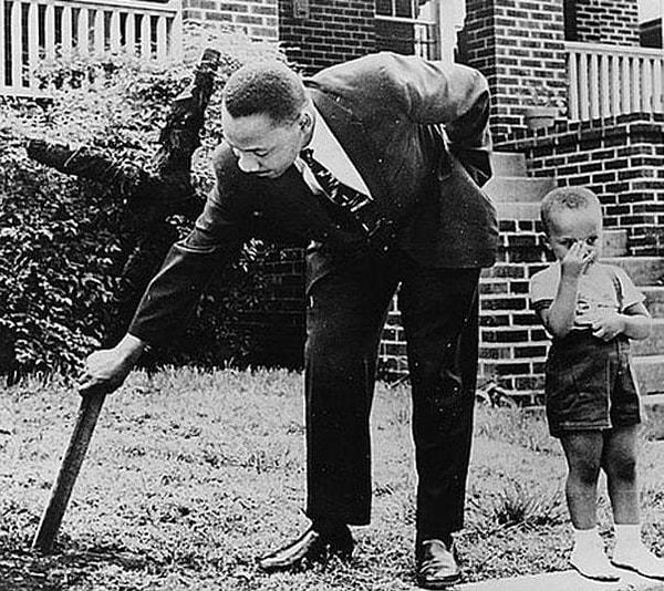 21. Martin Luther King oğluyla birlikte,bahçesine saplanmış yanık haçı söküyor.