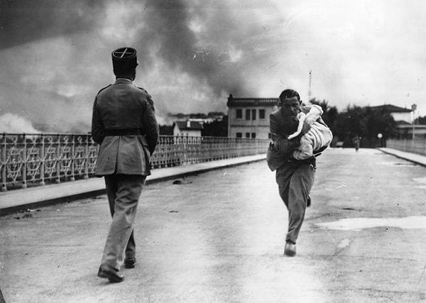 11. Bir gazeteci İç Savaşı sırasında bir bebeği kurtarmak için köprüyü geçerken. (1936)