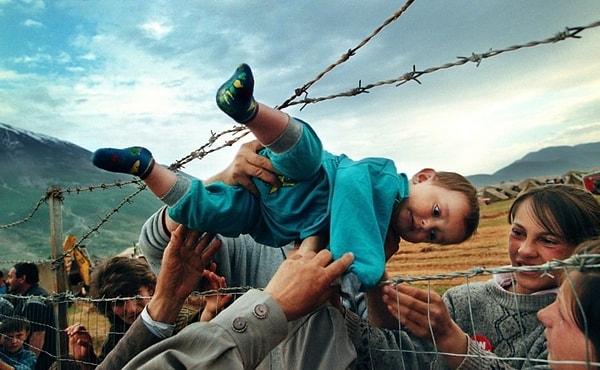 58. Agim Şala, Kosova Savaşı sırasında dedesini görmek için dikenli tellerin arasından geçiriliyor.