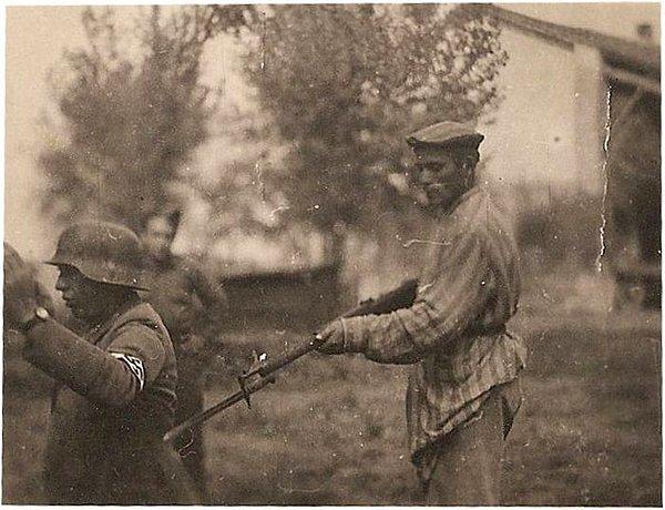 11. Özgürlüğüne kavuşmuş bir Yahudi, bir Nazi askerini namlunun ucunda tutarken