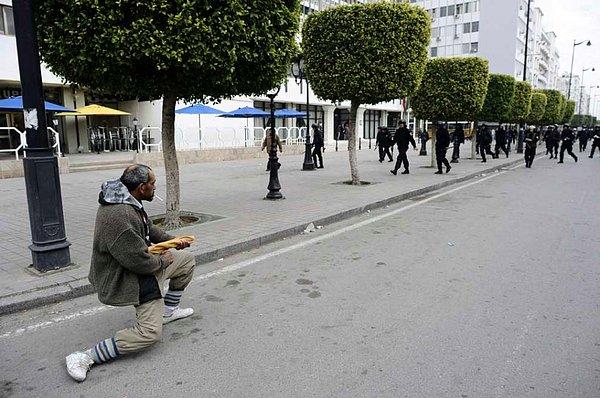7. Bir adam, Tunus Devrimi sırasında çevik kuvvet polisiyle yüzleşiyor. (2012)