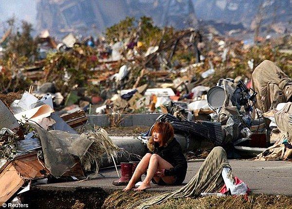 21. Japonya'da yaşanan tsunami felaketinde evini kaybeden kız ağlıyor. Fakat bütün bu olumsuzluklara rağmen büyük annesi ve iki köpeği kurtulmayı başardı. (2011)