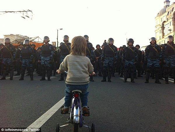 37. Bisikletli bir çocuk, Vladimir Putin'e karşı yapılan gösterilerde çevik kuvvet polisiyle karşı karşıya. (2012)