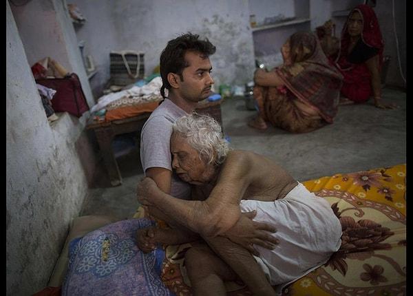 7. 97 yaşındaki Bhogla Devi acı içinde ve torunu onu rahatlatmaya çalışıyor.