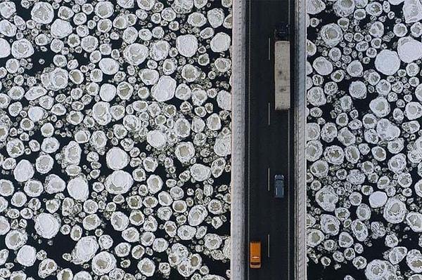 28. Buz tutmuş bir göl üzerinde bulunan köprünün havadan fotoğrafı.