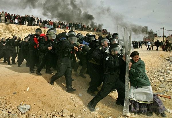 2006 yılında Batı Şeria'da çekilen fotoğrafta Israilli bir kadının İsrail güvenlik güçlerine direnmesini görüyoruz. Oded Balilty tarafından çekilen fotoğraf, İsrail'in Ramallah'a komşu olan bir yerleşim bölgesini boşaltma kararı vermesi sonucu, evini terk etmek istemeyen İsraillilerin polise karşı gelmesini gösteriyor.