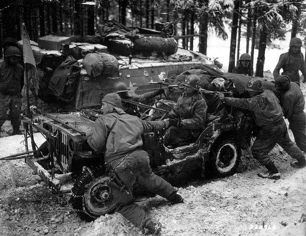 3. Amerikan askerleri ağır yaralı Alman askerlerini taşıyan aracı saplandığı çamurdan kurtarmaya çalışıyor (II. Dünya Savaşı).