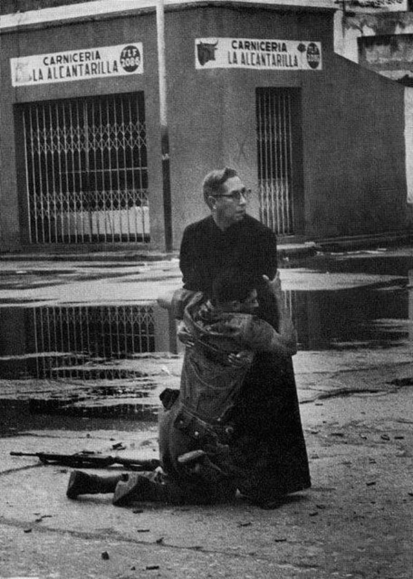 14. Keskin nişancının vurduğu yaralı askeri rahip son nefesinde rahat ettirmeye çalışıyor. (Venezuela, 1962)
