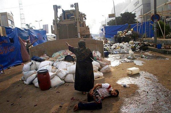 30. Yaşlı kadın askeri buldozerin önüne geçerek yaralı protestocuyu korumaya çalışıyor.(Mısır)