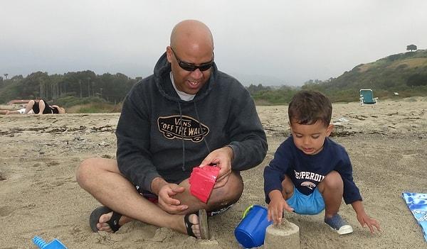 8. Plajda çocuğuyla kumdan kale yapan baba