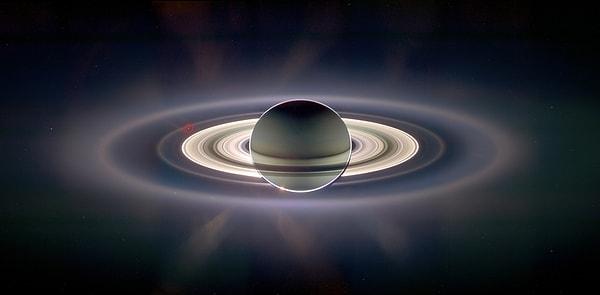 21. Cassini uzay aracı, Uzayın derinliklerinden Satürn'ün fotoğrafını çekmiş. Kırmızıyla işaretlenmiş küçük nokta ise Dünya. (2006)