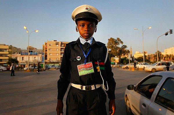 14. Bir sokak köşesinde duran 10 yaşındaki Ali Salem el-Faizani trafik polisliği yapıyor. Doğu Libya'da olan iç çatışmalar nedeniyle okullar 2 aydır kapalı ve Ali gibi çocuklarda zaman geçirmek için bu tarz işler yapıyorlar. 15 Nisan 2011