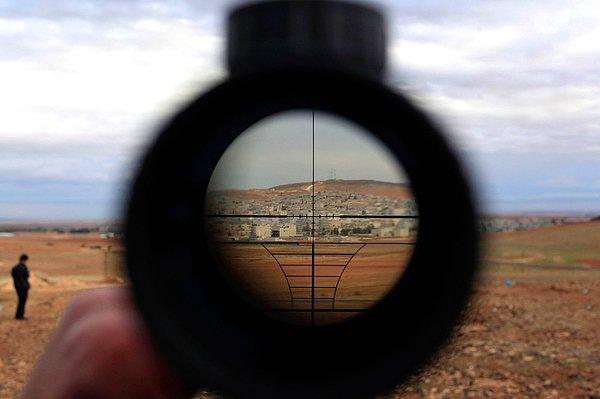 5. Murşitpınar'dan keskin nişancı tüfeğinin dürbünü ile Kobani'yi izleyen bir adam. Suruç, Şanlıurfa. 19 Ekim