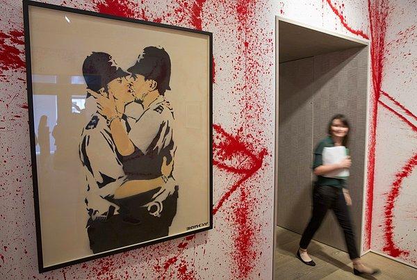 22. Banksy'nin oldukça iğneleyici ironiler içeren çalışmaları bile galerilere misafir olmuştu. Örneğin, iki İngiliz polisinin 'aşk kucaklaşması'nı resmettiği bu çalışma gibi.