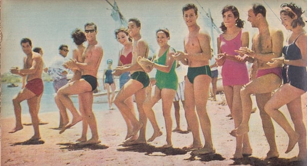 1. Yıl 1964, kadınlar ve erkekler yaz sıcaklarının tadını sahilde çıkarıyor.