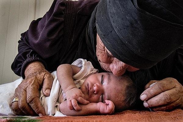 14. Ürdün'e kaçabilen Suriyeli anne, 10 günlük bebeğini öpüyor.