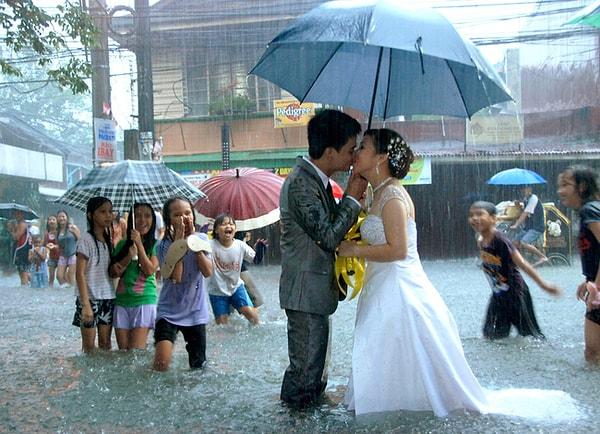 40. Muson yağmurları döneminde dünya evine giren bir çift öpüşüyor, Manila.