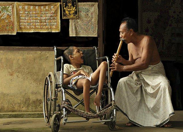 6.Balili bir baba engelli oğluna flüt çalarken.