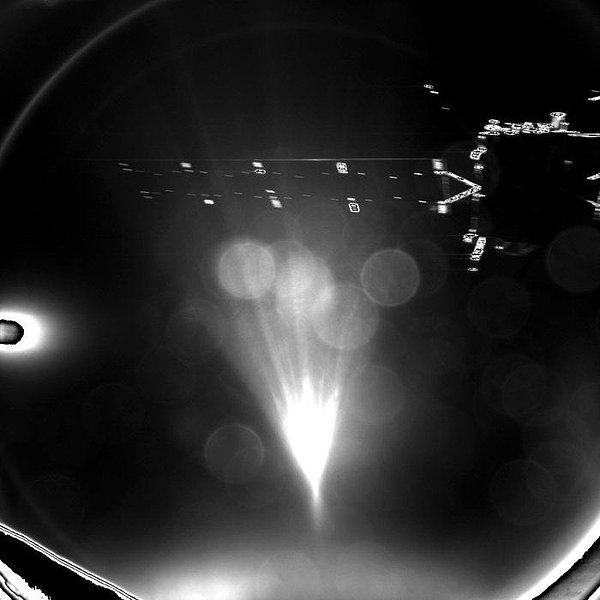 Philae'nin iniş esnasında çektiği ilk fotoğraf. Sağ üstte Rosetta'nın güneş panellerini görebilirsiniz.