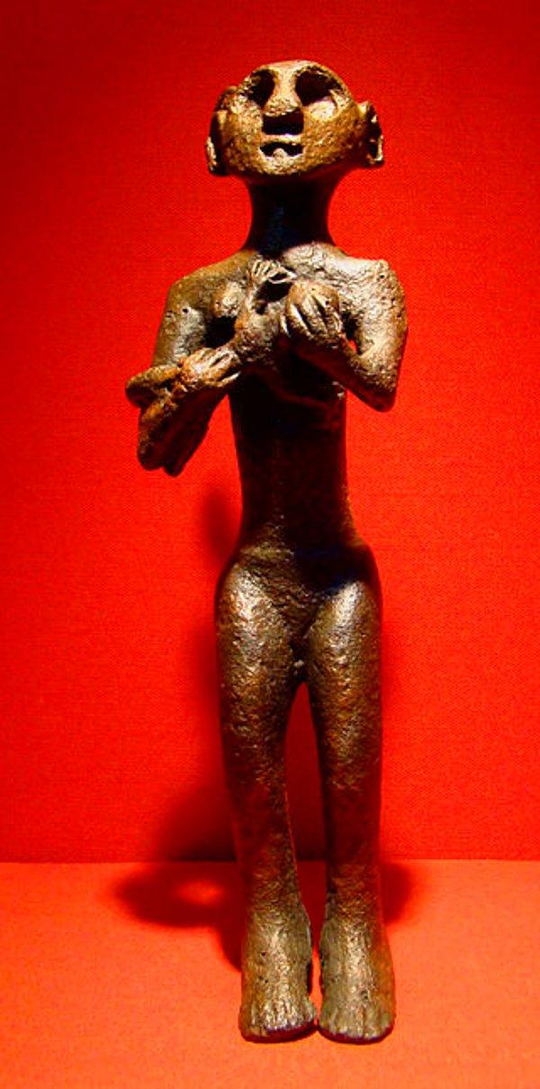 12. Horoztepe'de bir mezarda bulunan bebek emziren bronz çıplak kadın heykeli.