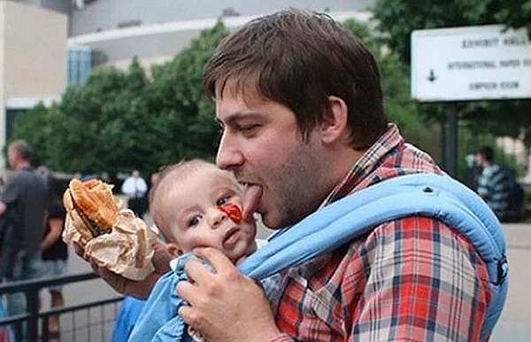 26. Отец пытается слизать кетчуп с лица своего сына.