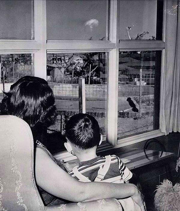 5. Las Vegas'ta bir anne ve oğlu, pencerelerinden 130 km uzakta gerçekleştirilen nükleer denemenin yarattığı mantar şeklindeki bulutu izlerken.