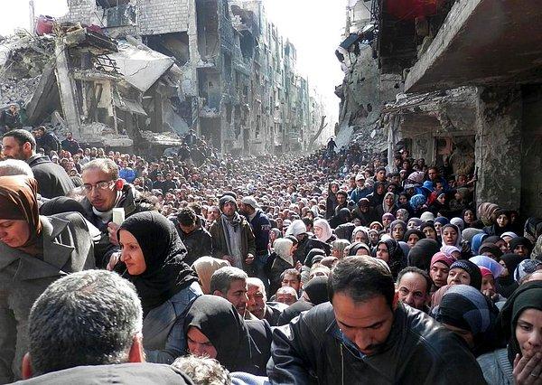 8. Şam'da bulunan Filistinli mülteci kampı yemek dağıtımı için sıraya giriyor.