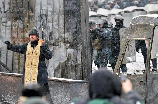 10. Kiev'de polis ve protestocular arasında çıkan çatışmayı yatıştırmaya çalışan Ortadoks rahip.