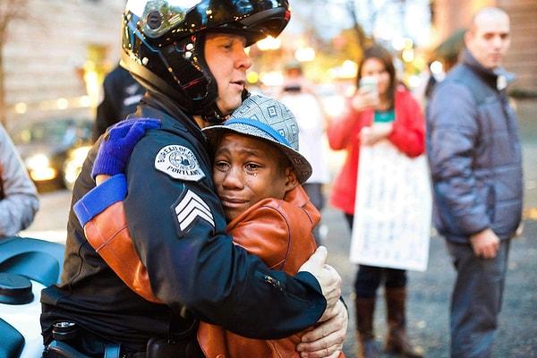 34. Ferguson protestolarını desteklemek için toplanan Portland halkından siyahi bir çocuk polise sarılıyor.