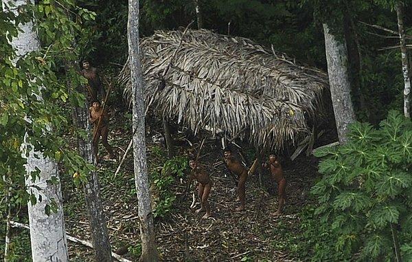 42. Henüz dünya ile iletişim kurmamış oldukları düşünülen ve Xinane Nehri yakınlarında yaşayan Amazon yerlilerinin gökyüzünde gördükleri uçağa şaşkın bakışları.