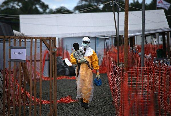 43. Liberya'da kanında Ebola bulunma ihtimali olan bir çocuk, bölgeye gönüllü giden bir doktor tarafından taşınıyor.