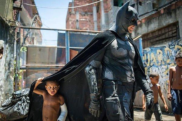 44. 2014 Dünya Kupası maçları sırasında Maracana'nın hemen yanında bulunan bir gecekondu mahallesinde yaşayan çocuklar, Batman kılığına girmiş bir adam ile oynuyor.