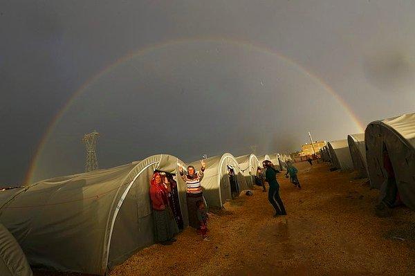 45. Kobani'den kaçarak Suruç'a gelen bir Kürt mülteci, gökkuşağının altında zafer işareti yapıyor.