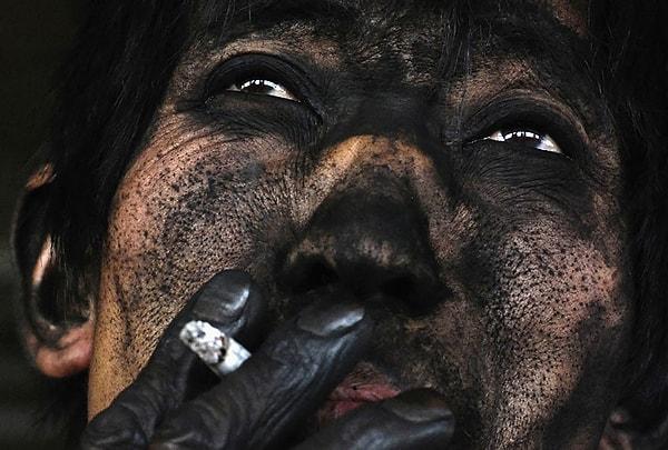 30. Changzhi'de bir kömür madeninde, vardiyasını bitiren bir maden işçisi sigarasını içiyor.