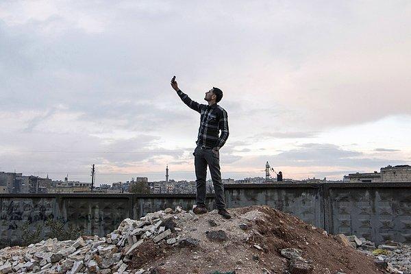 2. Halep'te telefonunun daha iyi çekmesi için uğraşan bir Suriyeli.