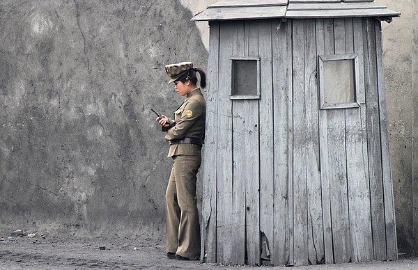 7. Kuzey Koreli bir kadın asker, telefonunu kullanırken.