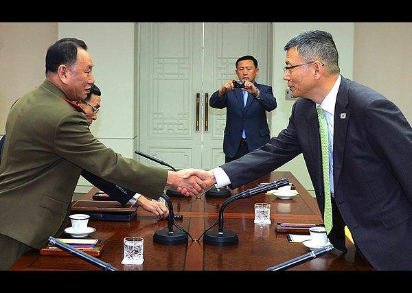 6. Kuzey ve Güney Koreli yetkililer, söz konusu masanın iki yanına oturarak görüşüyor.