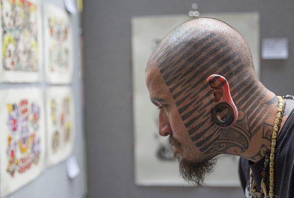 9. Londra'da 10.su düzenlenen Uluslararası Dövme Festivali'nde dövme dizaynlarına bakan adam. 27 Eylül 2014.