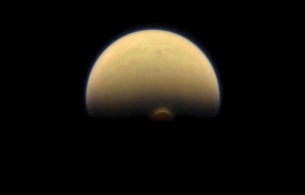 27. Karanlığa doğru dalarken. Satürn'ün uydusu Titan'ın Güney Kutbundaki girdabı. Ayrıca turuncu ve mavi puslu atmosferi Titan'ın karakteristik özelliğiymiş. Yine Cassini tarafından çekilen bu fotoğrafta, girdap Güneş ışığının ulaşabileceği oldukça yüksek bir yükseklikteyimiş.