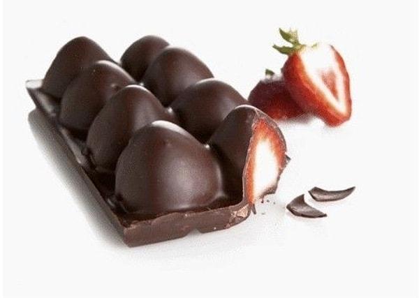 3. Önce eritilmiş çikolataları yarısına kadar kaba dökün ardından içlerine çilekleri batırın.