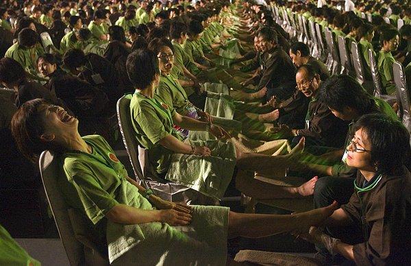 23. Guinness Dünya Rekoru için; 20 dakika boyunca ayak masajı yaptıran 2.000 katılımcı ve buna alışık olmayan aralarındaki Japon kadın