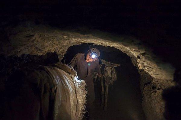 9. Pakistan'da bir madende eşekleri yukarı çıkartan genç bir madenci. Buradan çıkarılan kömürler, eşeklerin sırtına yüklenerek yukarı çıkartılıyor.