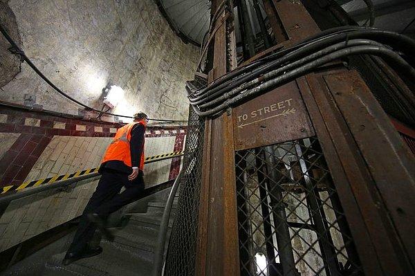 15. Londra'da artık kullanımda olmayan yer altı istasyonunun merdivenlerinden çıkan bir işçi.