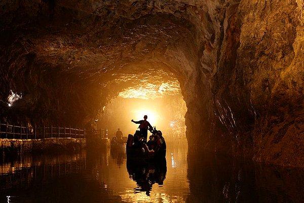 21. Kuzey Tayvan'da bulunan su tünelinde geleneksel bir botla gezen turistler.