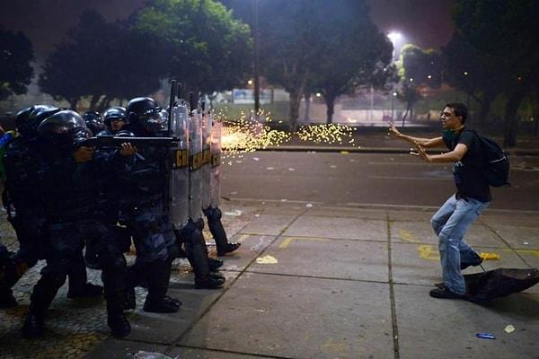 2. Brezilyalı bir protestocu yolsuzluk ve polis şiddetine karşı yapılan protestolar sırasında polislere engel olmaya çalışıyor: