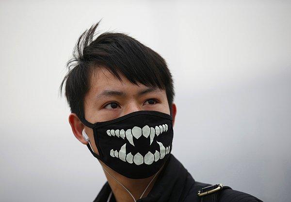 28. Çin'de hava kirliliği ve sis alarmı verilmesinin hemen ardından maske takarak dolaşan genç.